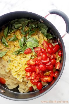 a bowl filled with pasta and tomatoes on top of a table