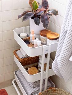 a white shelf with some items in it and a potted plant on the side