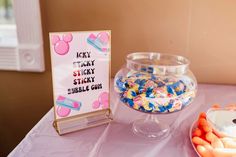 there is a candy bowl and sign on the table