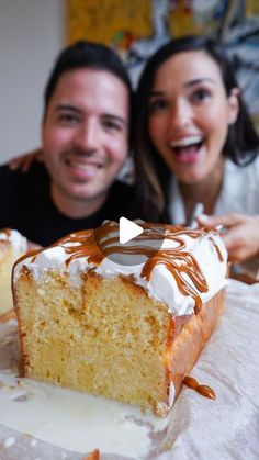 a man and woman sitting at a table with a slice of cake in front of them