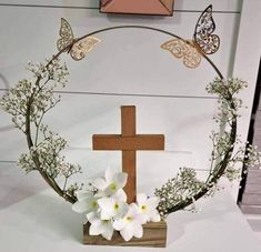 a cross with flowers and butterflies around it