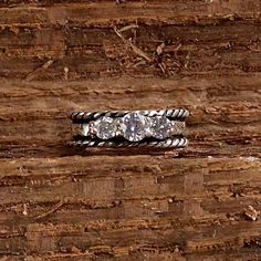 three diamond rings sitting on top of a piece of wood