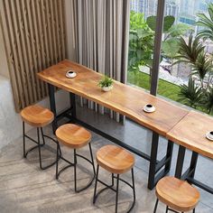 three stools and a table in front of a large window with city view outside