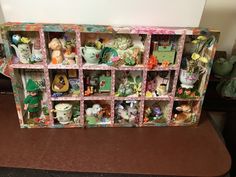 a shelf filled with lots of figurines sitting on top of a table