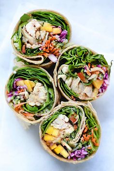 four wraps filled with different types of food