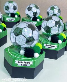 several soccer balls are sitting on top of each other, with green and white pom - poms around them