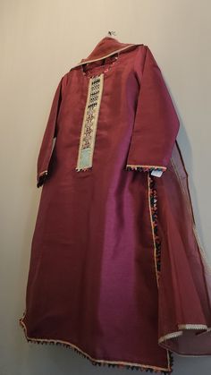 This is a raw silk  dress with organza dupatta and wide pants.  Size and length medium. The actual  color is maroon Formal Organza Kurta With Naqshi Detailing, Formal Naqshi Organza Kurta, Formal Cotton Silk Dupatta With Dabka, Formal Cotton Silk Lawn Suit With Dabka, Red Tissue Silk Kurta With Dabka Work, Red Organza Unstitched Suit, Eid Lawn Suit In Tussar Silk With Dabka Embroidery, Eid Lawn Suit In Tussar Silk With Dabka, Eid Tussar Silk Lawn Suit With Dabka