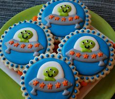 four decorated cookies sitting on top of a green plate