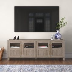 an entertainment center in a living room with a large television mounted on the wall