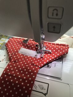 the sewing machine is working on the red and white polka dot fabric