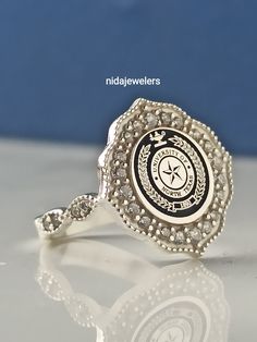 This product is GUARANTEED for life. * College graduation rings for men and women delicately engraved with your school logo or any other initials or image you want. * The ring has solid back. Deep and detailed engraving very delicately handcrafted unisex - looks super cool on both women & men * The ring is 925 Silver * Please contact me for your 14 carat and 18 carat solid gold requests. I can gladly do. * Certified 14k solid gold, hallmarked 14k for solid gold rings. * The ring has solid ba Silver Sterling Silver Halo Ring Gift, Unique Sterling Silver Engraved Ring For Anniversary, White Gold Sterling Silver Signet Ring With Halo Setting, Silver Engraved Ring With Center Stone For Gift, Unique Silver Cluster Promise Ring, Unique Silver Cluster Ring For Promise, Engraved Sterling Silver Diamond Ring For Anniversary, Sterling Silver Signet Ring With Accent Stones, Hallmarked Silver Heirloom Cluster Ring