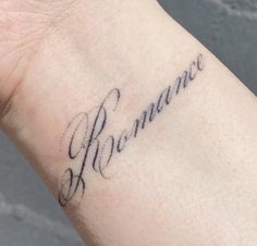 a small wrist tattoo with the word remain on it's left arm and in cursive writing