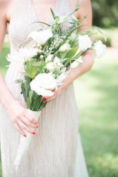 a woman holding a bouquet of white flowers