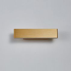 a gold rectangular object on a white surface with no one in the photo to describe it