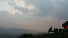 a group of people standing at the top of a hill with a red light in front of them