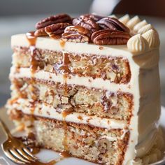 a slice of cake with pecans on top and caramel sauce drizzled over it