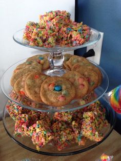 some cookies and sprinkles are in a glass bowl on a counter top