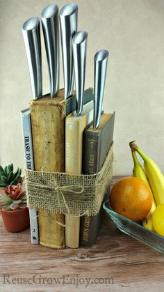 an open book sitting on top of a wooden table next to fruit and books with scissors