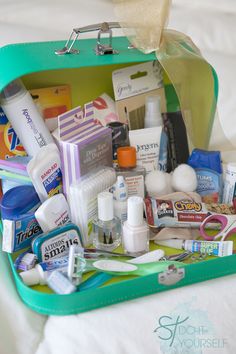 an open green suitcase filled with personal care items on top of a white sheet covered bed