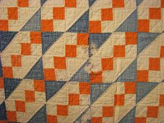 an orange and blue checkered quilt on display