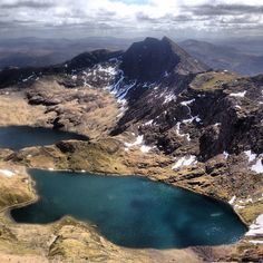 the mountains are covered with snow and blue water in the foreground is a lake