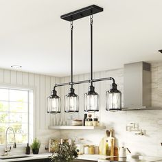 a kitchen with an island, sink and hanging lights