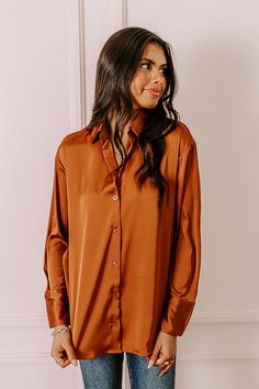 - This versatile top is perfect for a stylish look day or night! - Unlined material with a satin finish - A collared v-cut neckline - A button-up front - Long, loose sleeves with button closure cuffs - A relaxed silhouette that ends in a rounded hemline Solid Satin Top With Button Closure, Satin Top With Button Closure, Fall Button-up Satin Blouse, Fall Satin Button-up Blouse, Casual Satin Tops For Fall, Fall Satin Blouse With Button Closure, Casual Satin Blouse For Fall, Loose Sleeves, V Cut