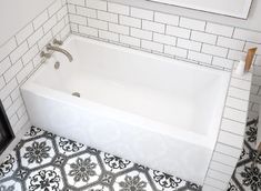 a bath tub sitting in the middle of a bathroom next to a framed painting on the wall