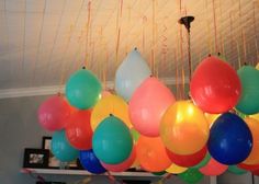 many balloons are hanging from the ceiling with streamers