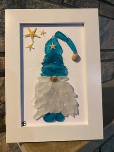 a blue and white framed glass christmas ornament with a star on the top