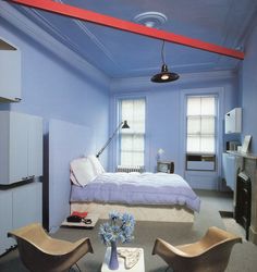 a bedroom with blue walls and furniture in it