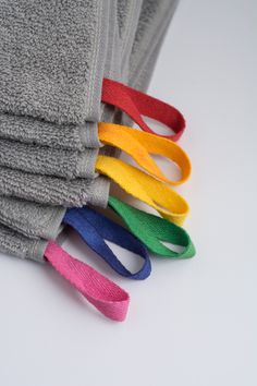 several different colored ties are stacked on top of each other in front of a white background