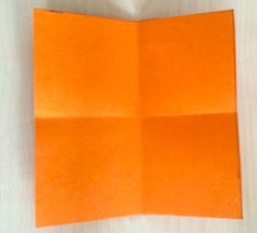 an orange folded piece of paper sitting on top of a table