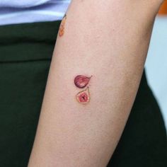 a woman's arm with a small piece of fruit tattoo on her left arm