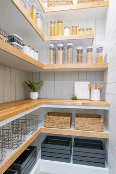 an organized pantry with wooden shelves and baskets