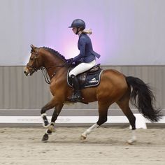 a woman riding on the back of a brown horse