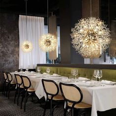 the dining room is set with white tablecloths and chairs, chandeliers hanging from the ceiling