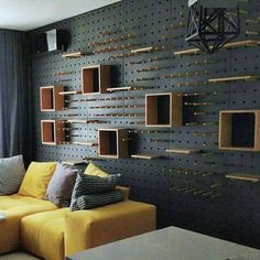 a yellow couch sitting in front of a wall mounted wooden shelves on it's side