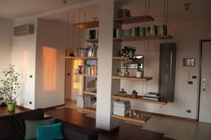 a living room filled with furniture and bookshelves next to a wall mounted book shelf