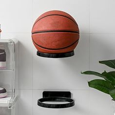 a basketball hanging on the wall next to a shoe rack with shoes and other items