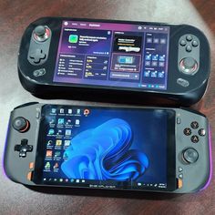 two game controllers sitting next to each other on top of a wooden table in front of a cell phone