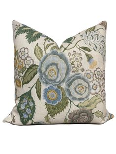 a white pillow with blue and green flowers on it