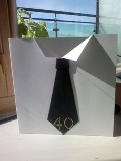 a white box with a black tie on it and the number forty written in gold