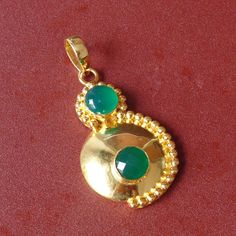 A deep green hue makes this green onyx pendant a beautiful go-to accessory. this 18k gold-finished pendant to elegantly accent your look. 18K Gold Plated Pendant, Green Onyx Pendant, May Birthstone Pendant, Designer Pendant, Round Stone Pendant, Matching Jewelry, Gift For Women Product Details Item Code: BJBP-1499 Stone Name: Green Onyx Stone Size: 10 mm  Metal:  18K Yellow Gold Plated Over Brass Pendant Size: 5.00 X 3.00 Cms Note :- This pendants you will receive may vary slightly in color from Green Pearl Pendant Jewelry Gift, Green Pearl Pendant Jewelry As Gift, Green Gold-plated Emerald Pendant Necklace, Green Emerald Gold-plated Pendant Necklace, Green Pearl Pendant Jewelry, Gold Plated Green Emerald Necklace, Green Onyx Jewelry Gift, Green Round Gold Plated Emerald Necklace, Gold Emerald Necklace With Pearl Pendant As Gift