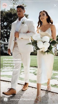 a man in a white suit and tie standing next to a woman in a white dress