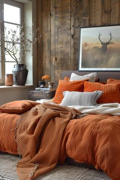 a bed with an orange comforter and pillows