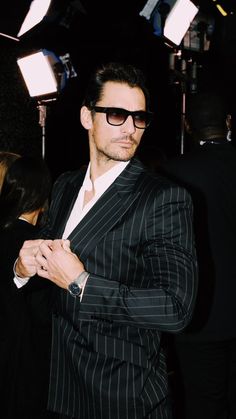 a man in a suit and sunglasses posing for the camera