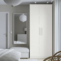 a bedroom with a bed, closet and white furniture in it's center area