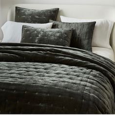 a bed covered in black and white pillows