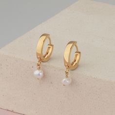 Small hoop earrings with a tiny pearl charm, freshwater pearl on a small hoops earring made of 14k gold filled. These dainty earrings are perfect to wear in the ear lobe, as a first piercing. Minimalist earrings are just perfect and really easy to wear and combine with more earrings. With the latch, backs make them really comfy to wear every day and on every occasion. Hoops size 16mm Pearl charm size 6mm This listing is for a PAIR of hoops earrings. Take a look at the matching necklace: https:// Everyday Pearl Charm Dangle Huggie Earrings, Minimalist Pearl Dangle Huggie Earrings, Minimalist Dangle Huggie Earrings With Pearl Charm, Dainty Huggie Earrings With Dangle Pearl Charm, Dainty Dangle Huggie Earrings With Pearl Charm, Dainty Small Hoop Pearl Earrings With Charm, Dainty Pearl Charm Dangle Huggie Earrings, Delicate Dangle Hoop Earrings With Pearl Charm, Dainty Hoop Pearl Earrings For Pierced Ears